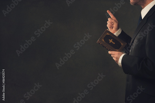 Obraz na plátně Man with a Bible and a wagging finger