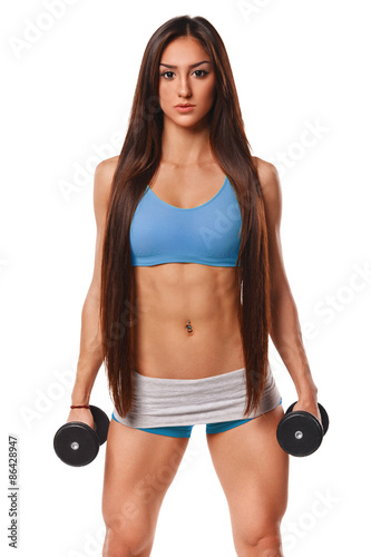 Beautiful athletic woman with long hair working out with dumbbells. Fitness girl showing muscular athletic body, abs. Isolated on white background