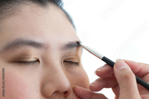 eye makeup with brush on pretty woman face © sutichak