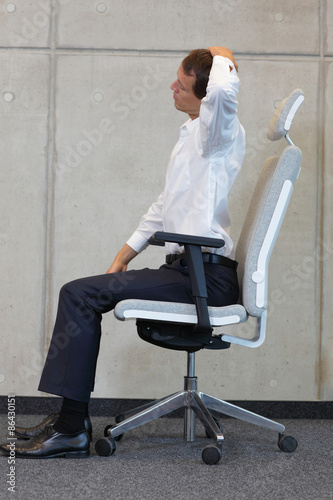 yoga with chair in office - business man exercising