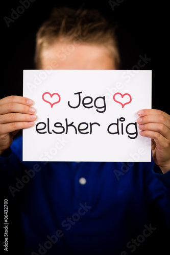 Child holding sign with Danish words Jeg Elsker Dig - I Love You