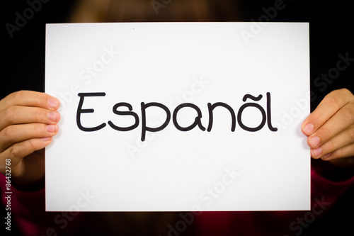 Child holding sign with Spanish word Espanol - Spanish in Englis photo
