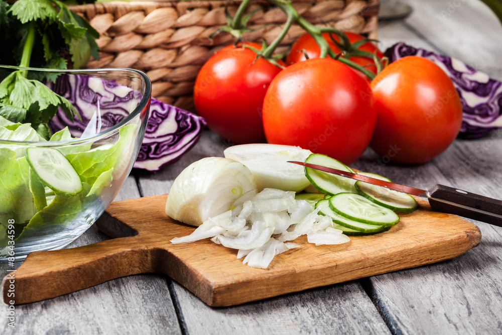 Chopped vegetables: onion and cucumber on cutting board Chopped vegetables: onion and cucumber on cutting board