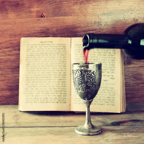 vintage shabbath silver cup of wine in front of torah book
 photo