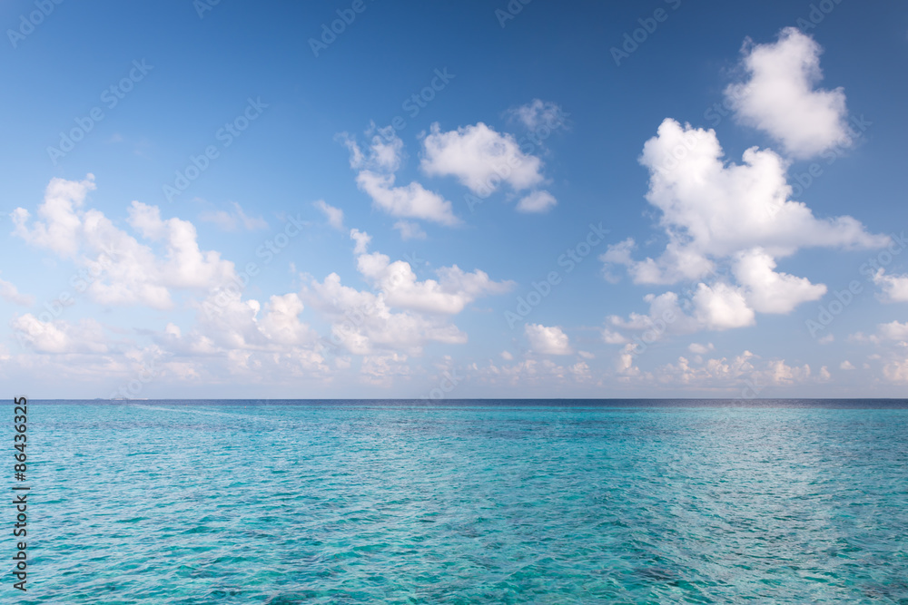 Tropical turquoise lagoon in  Indian Ocean. Bright blue sky with clouds. Used a polarizing filter