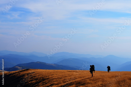 two backpackers hiking in mountains