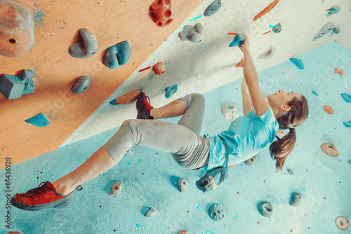 Young woman training in climbing gym