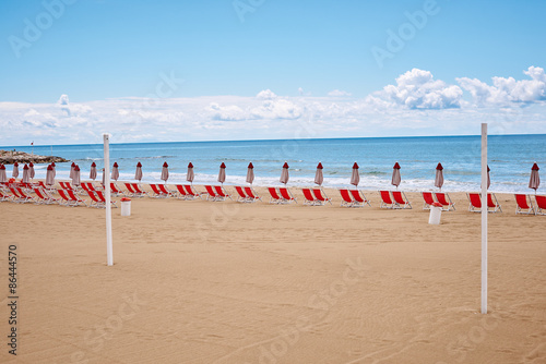 A beach with umbrellas and sun beds on coast