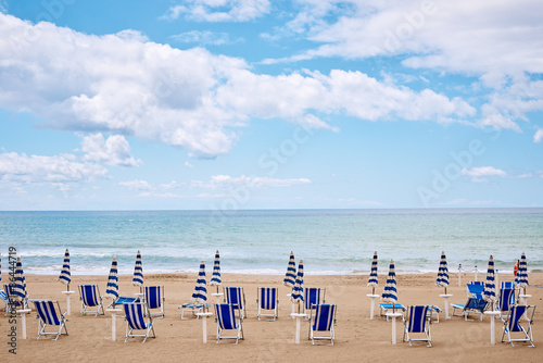 Fototapeta Naklejka Na Ścianę i Meble -  A beach with umbrellas and sun beds on coast