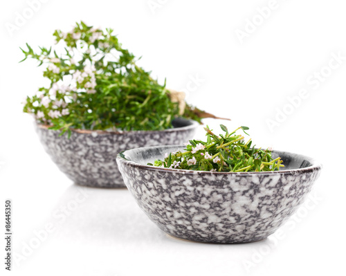 Thyme in bowl isolated on white background.