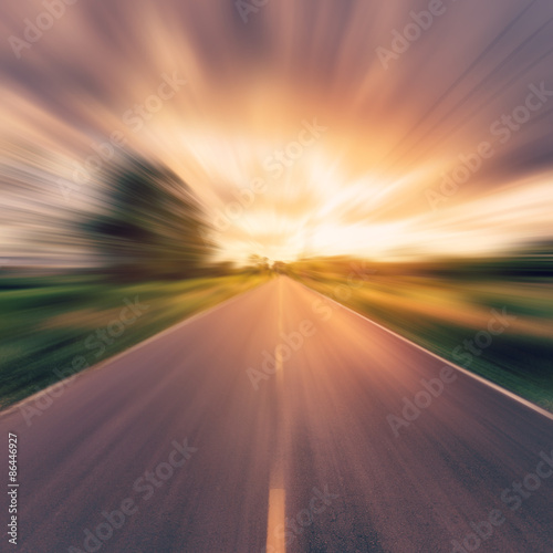 archiwalne zdjęcie kraju drogi asfaltowej w ruchu rozmycie o zachodzie słońca.