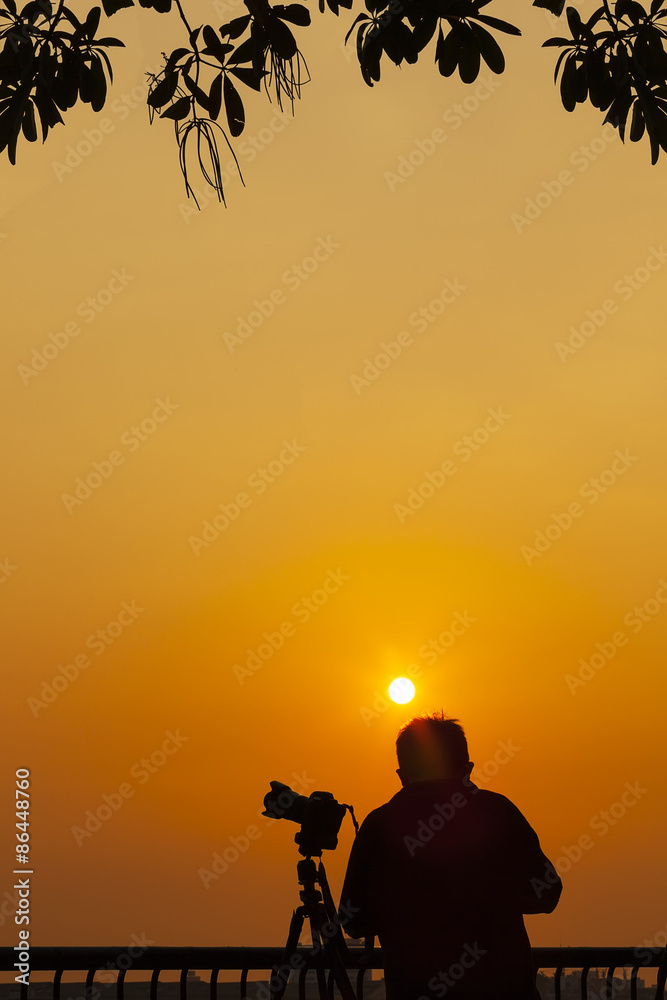 Silhouette of photographer take a rest at sunset Silhouette of photographer take a rest at sunset