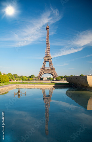 letni dzień słońce świeci nad symbolem paryskiej wieży Eiffla.