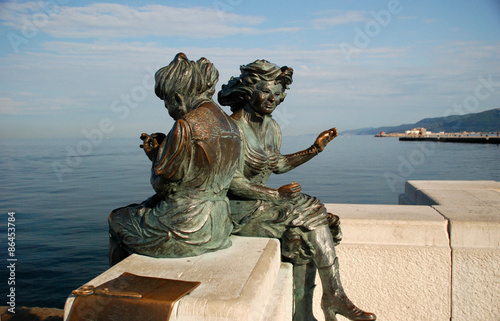 Statue of two women near the sea in Trieste, Italy