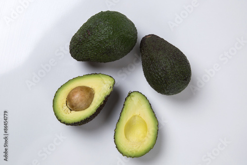 Some avocados over a wooden surface.