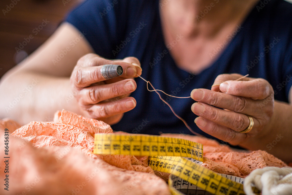Donna su misura usando ago e filo per cucire