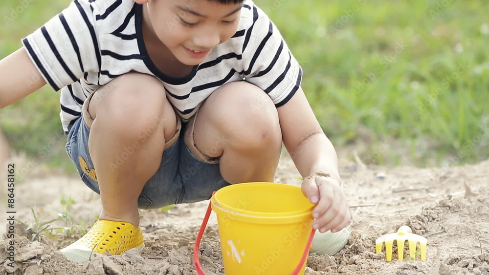 Asian cute boy playing with toys in garden, Asian cute boy playing with toys in garden,