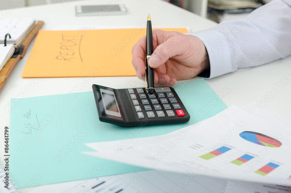 Businessman typing on a calculator Businessman typing on a calculator