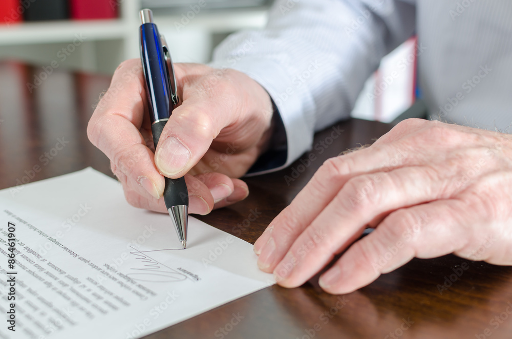 Businessman signing a document Businessman signing a document