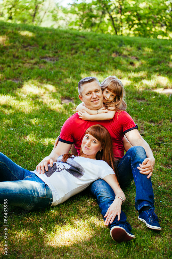 Fototapeta premium A young family, a pregnant mother, father, daughter