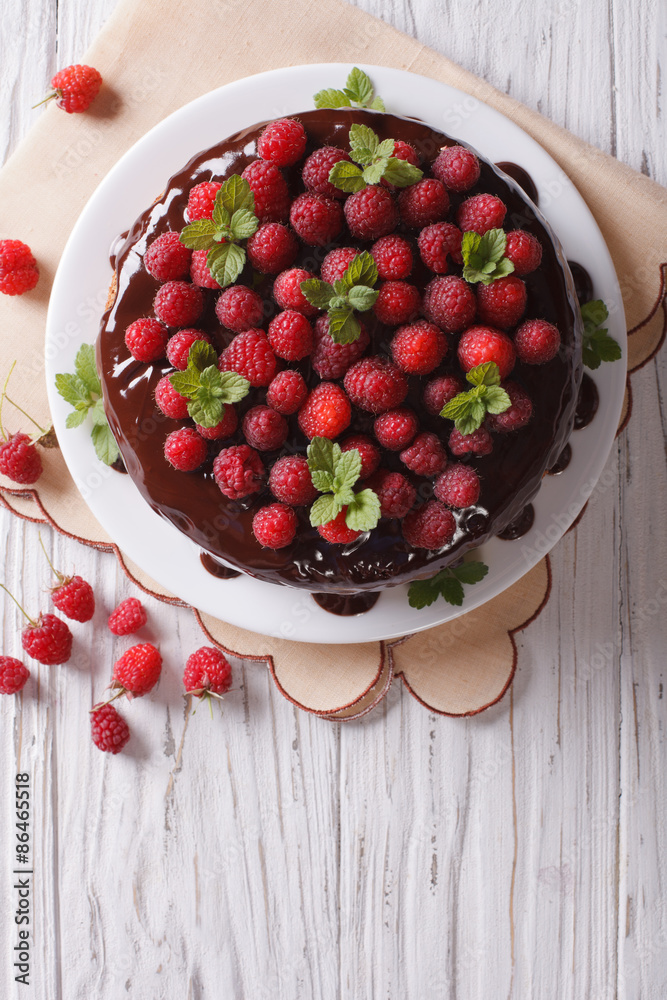 Chocolate cake with raspberries and mint on the table vertical top view
