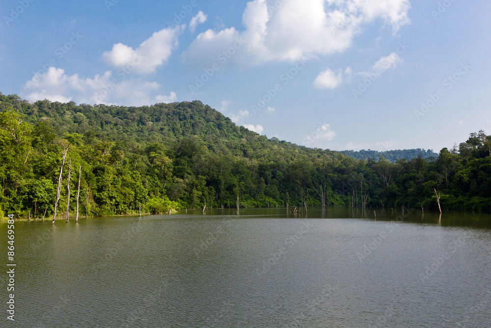 The reservoir with blue sky, clouds, mountain and trees The reservoir with blue sky, clouds, mountain and trees