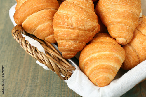 Croissants in a basket on wooden background