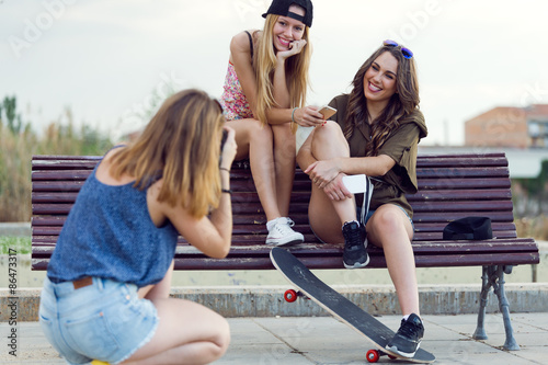 Beautiful young women using mobile phone in the street.