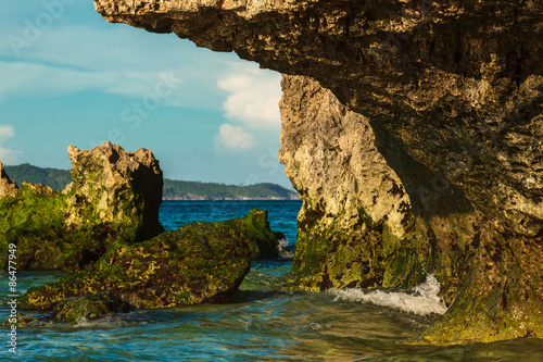 Tropical rock island with green stones on deep blue summer sea Philippines Boracay island