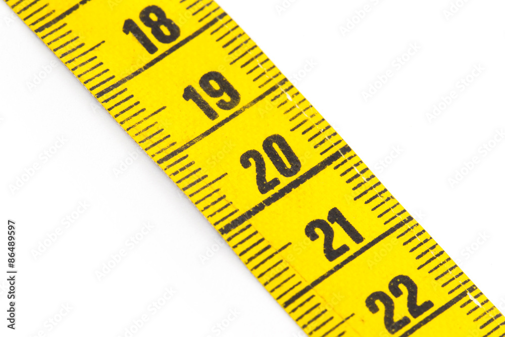 Yellow measuring tape isolated - selective focus Yellow measuring tape isolated - selective focus