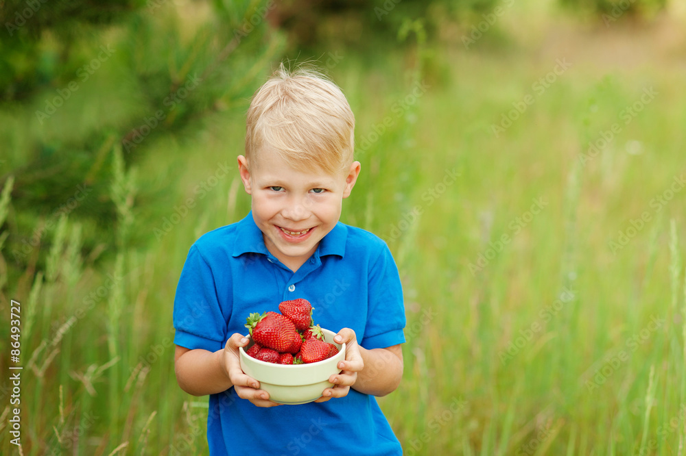 happy boy holding a plate with strawberries happy boy holding a plate with strawberries