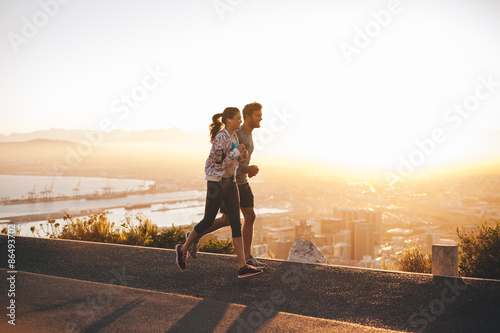 Young couple jogging on hillside road