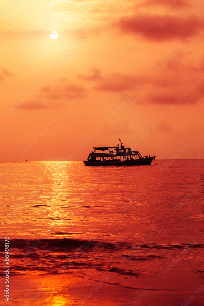 Fishing boat sailing over ocean water at sunset, Golf of Thailand