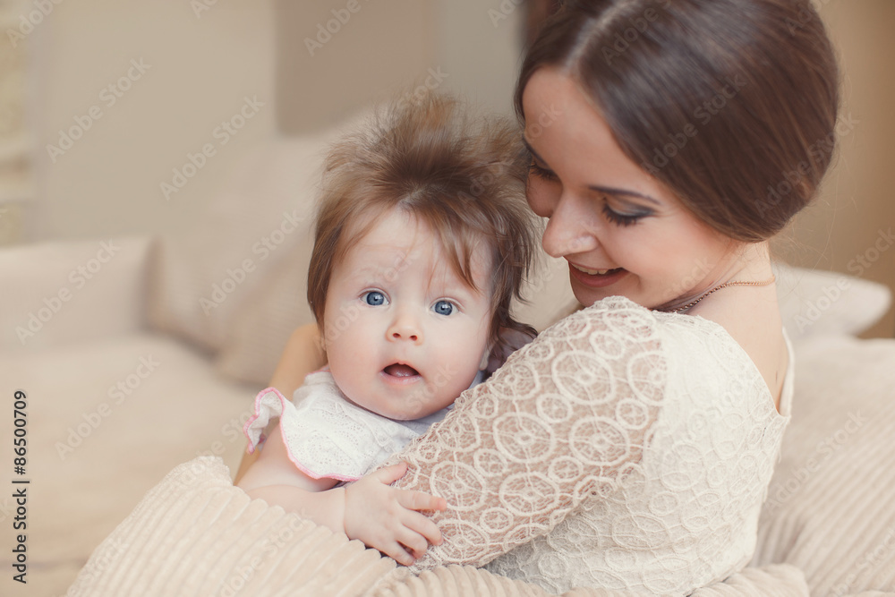 Portrait of happy mother with baby,posing lying on the bed Portrait of happy mother with baby,posing lying on the bed