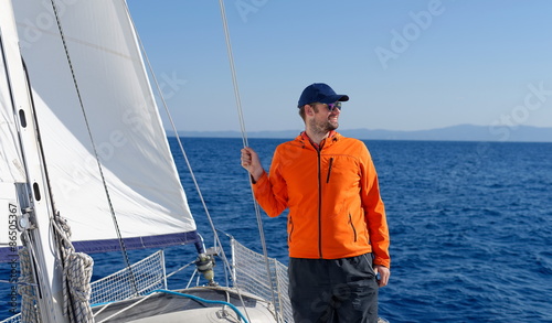 Man sailing with sails out on a sunny day © Visionsi