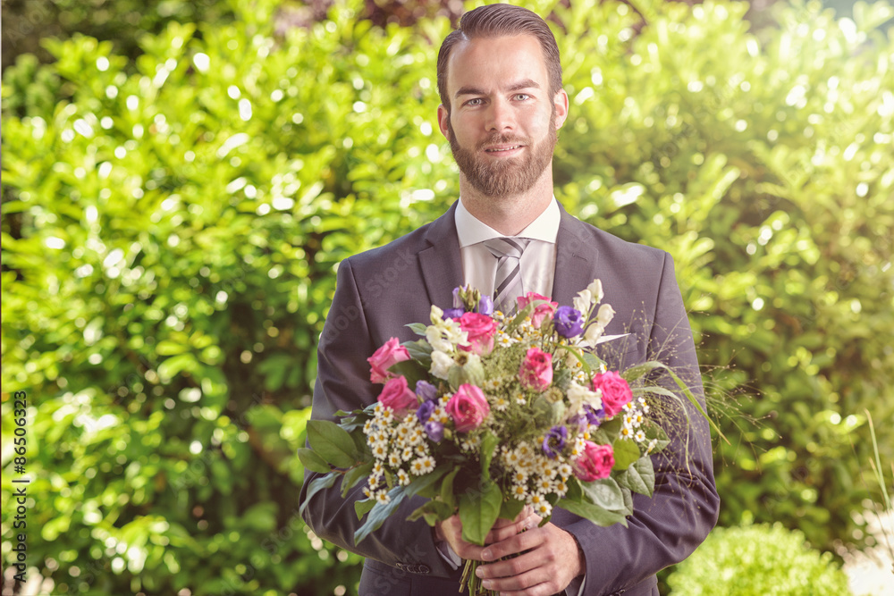 Handsome man in a suit carrying flowers Handsome man in a suit carrying flowers
