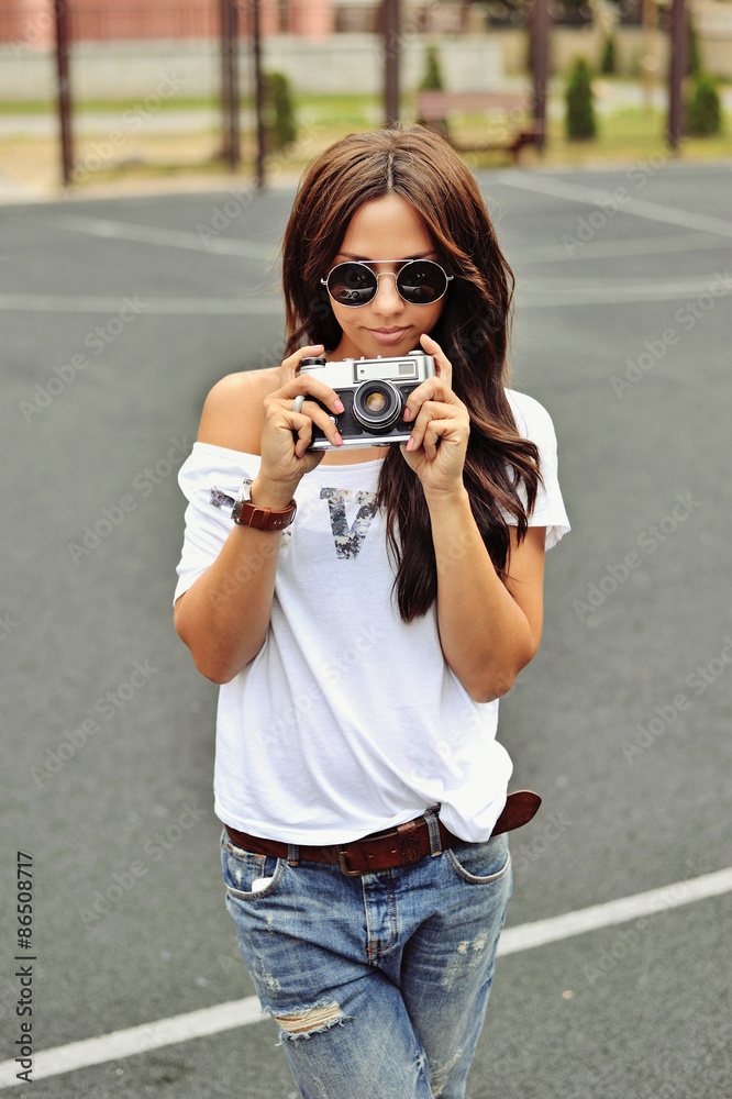 Beautiful girl photographer with old camera