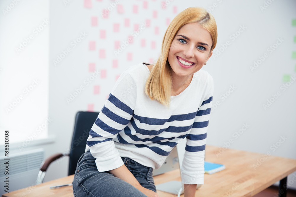 Businesswoman sitting on the table in office Businesswoman sitting on the table in office