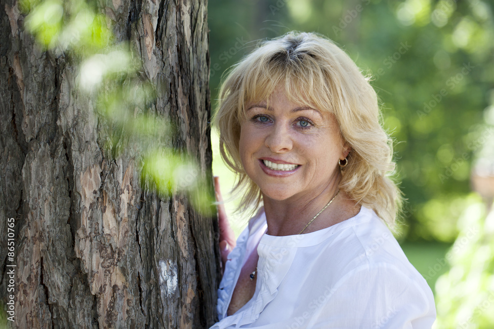 Portrait of lovely middle aged woman in the summer park Portrait of lovely middle aged woman in the summer park