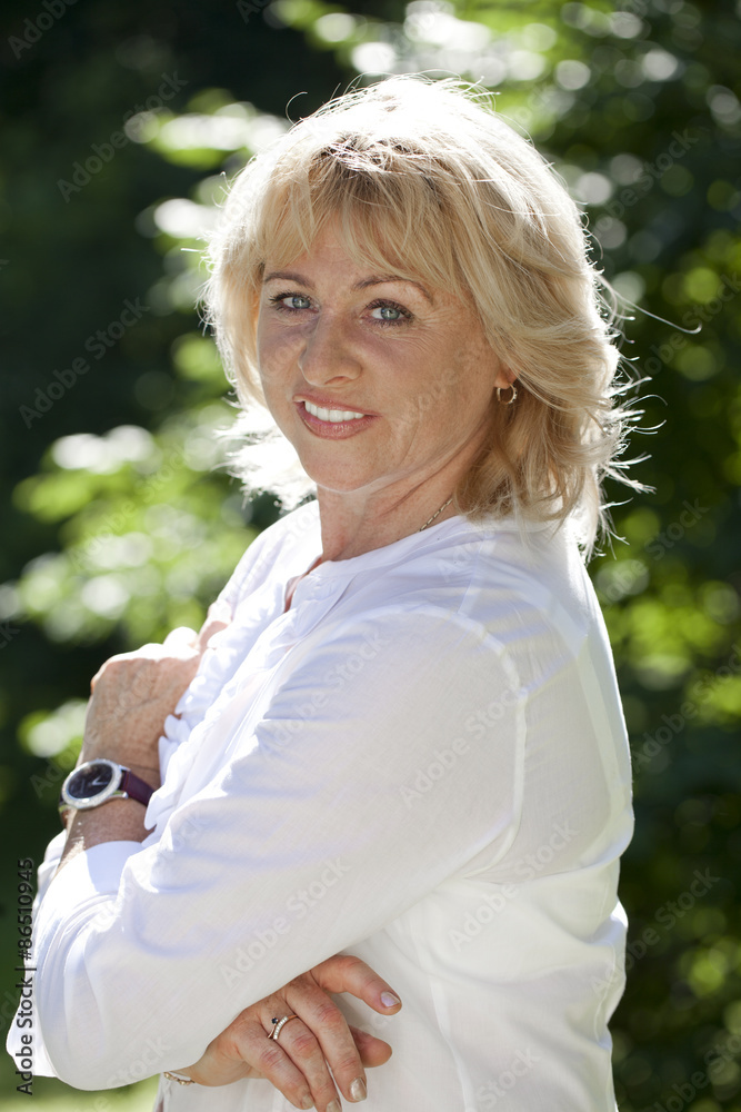 Portrait of serene mature woman in the summer park Portrait of serene mature woman in the summer park