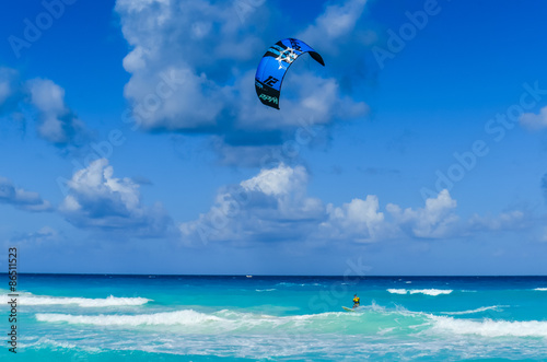 Male paraglider glides over the sea