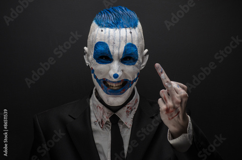 Fotografiet Terrible clown and Halloween theme: Crazy blue clown in black suit isolated on a