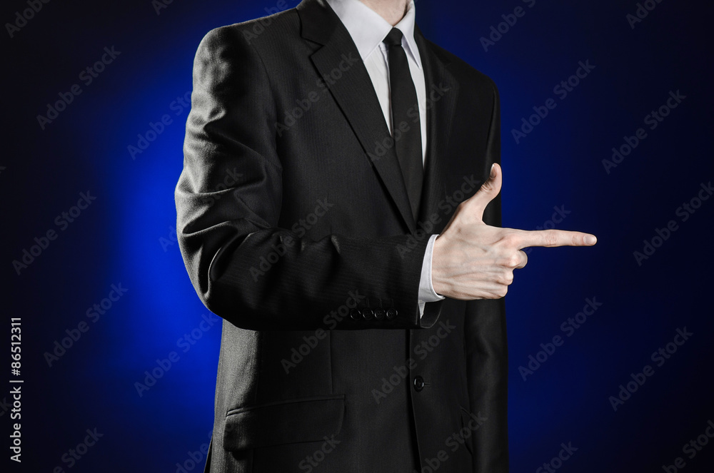 Business and the presentation of the theme: man in a black suit showing hand gestures on a dark blue background in studio isolated Business and the presentation of the theme: man in a black suit showing hand gestures on a dark blue background in studio isolated