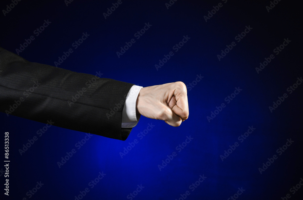 Obraz premium Businessman and gesture topic: a man in a black suit and white shirt showing hand gesture on an isolated dark blue background in studio