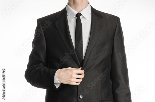 Businessman and gesture topic: a man in a black suit with a tie coat straightens his arms isolated on a white background in studio