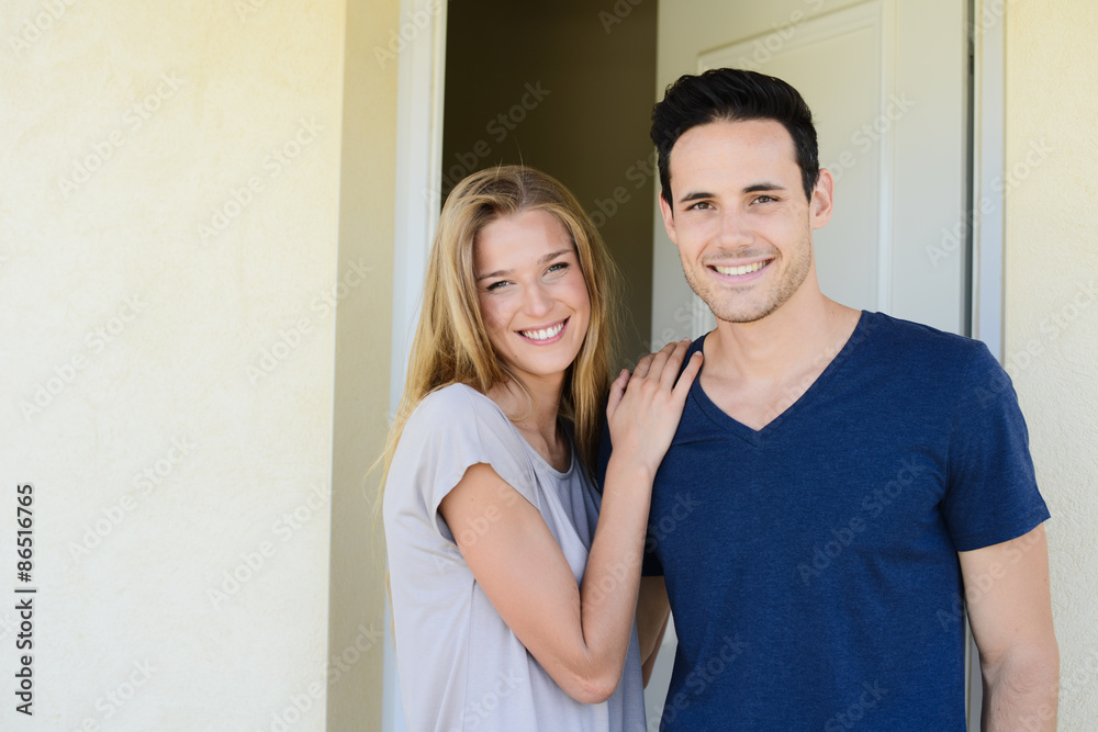 happy young couple man and woman opening door of their new home entrance happy young couple man and woman opening door of their new home entrance
