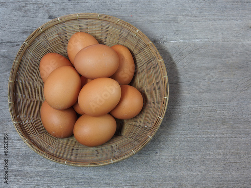 Fresh eggs in basket on wooden background