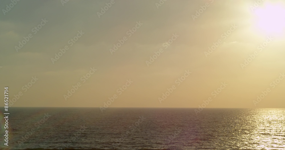 Beautiful Mediterranean sunset, blue waves and yellow-pink sunset. In the sky flying a triangular kite Beautiful Mediterranean sunset, blue waves and yellow-pink sunset. In the sky flying a triangular kite