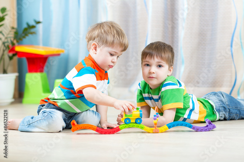 children playing rail road toy in nursery