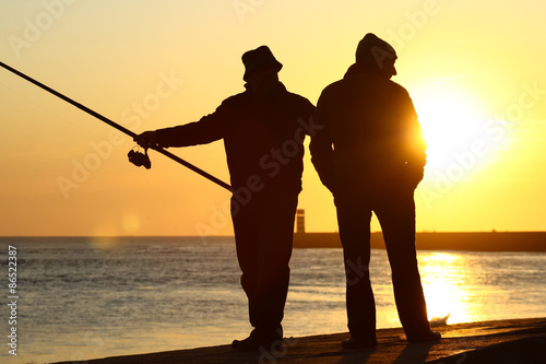 Homens a pescar ao por-do-sol. photo